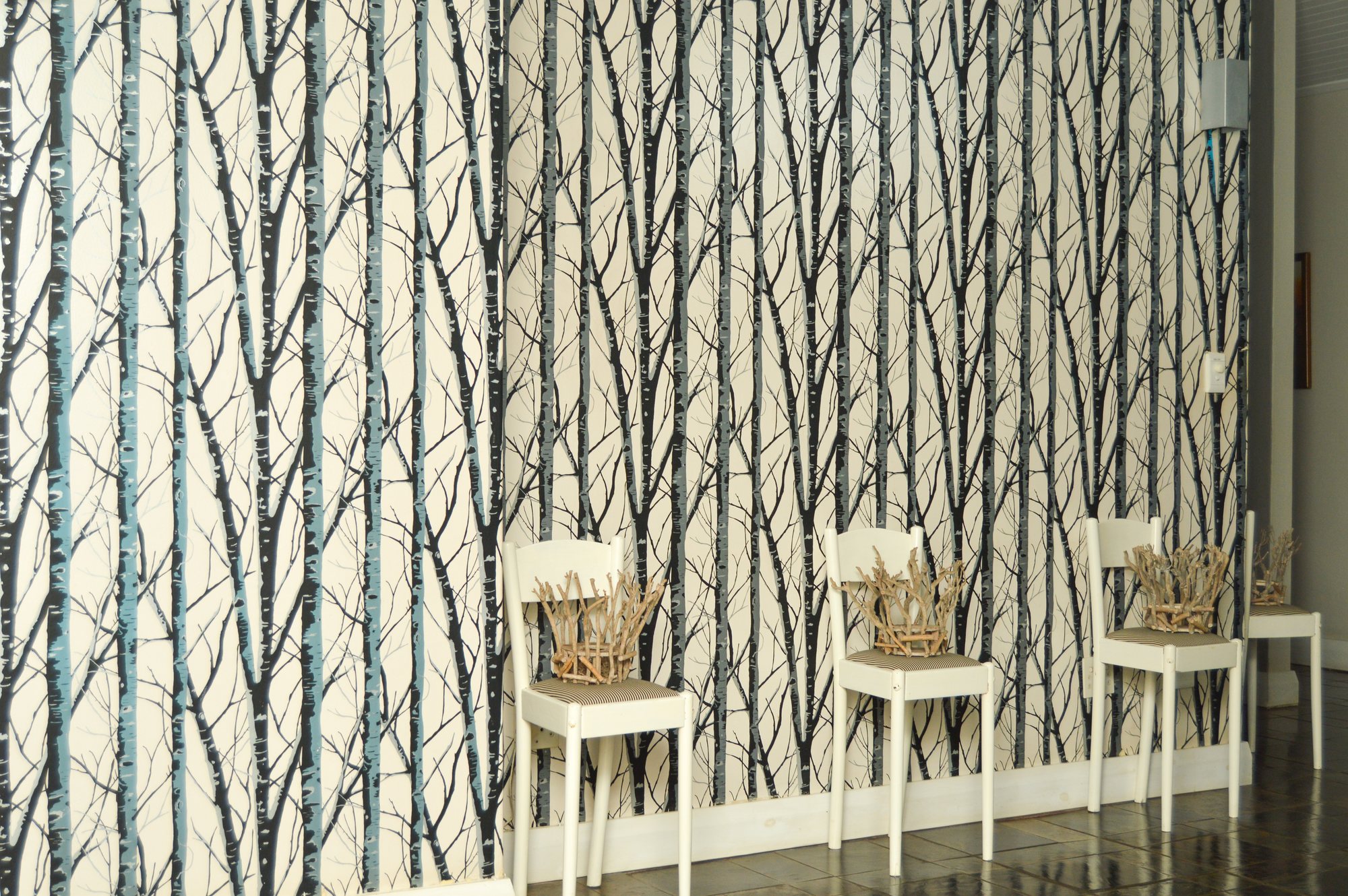 Breakfast nook at Yellowwoods with woodland-print wallpaper and white chairs